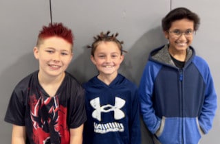 Three Mayflower students posing together indoors