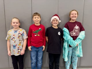 Four Mayflower students posing together in festive clothing
