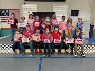 Mayflower students holding certificates at a school assembly