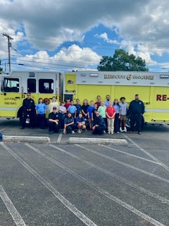 Mayflower students and adults gathered outdoors near emergency vehicles